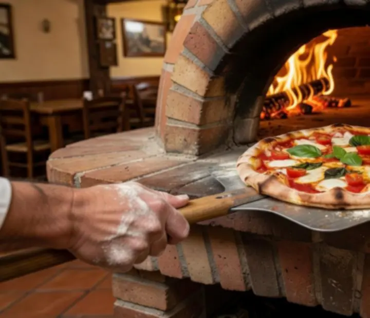 Close-up of a wood-fired Italian pizza coming out of a stone oven